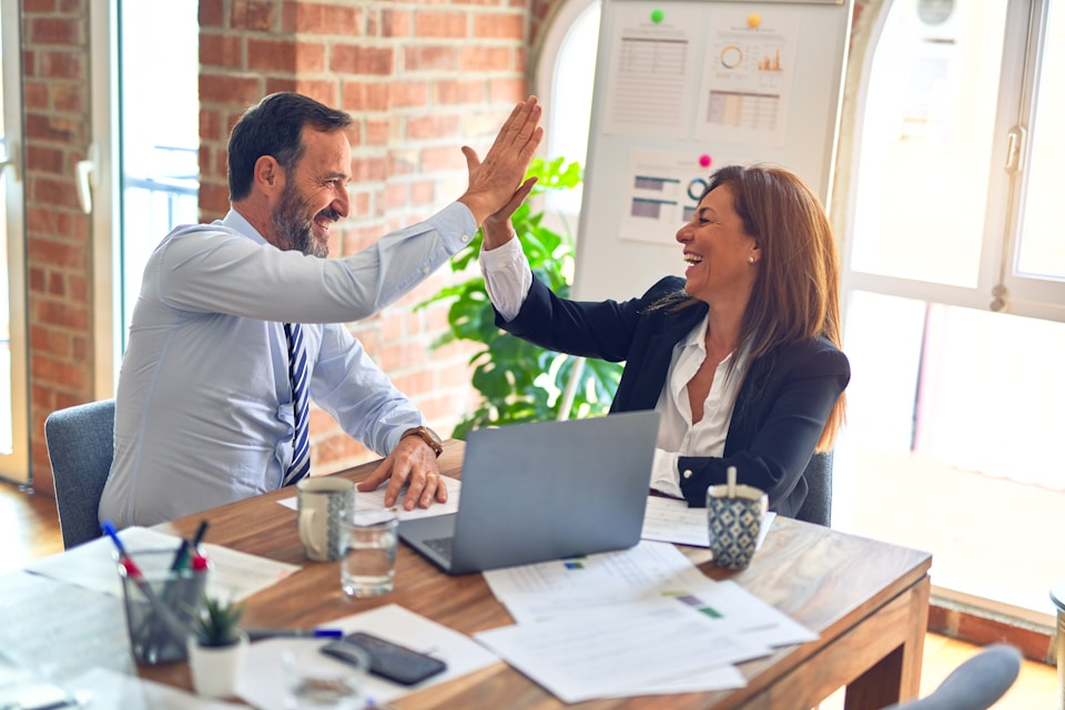 Business team collaborating and celebrating success with One Click Business Suite